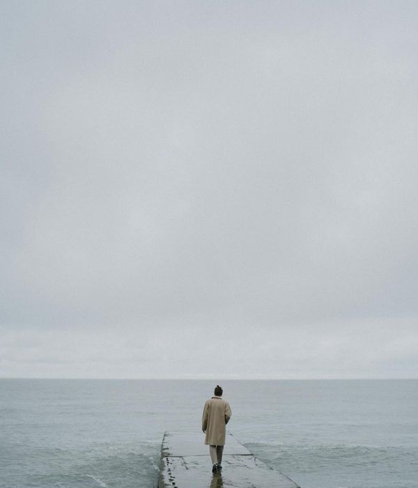Person meditating peacefully in a calm, minimalist environment.